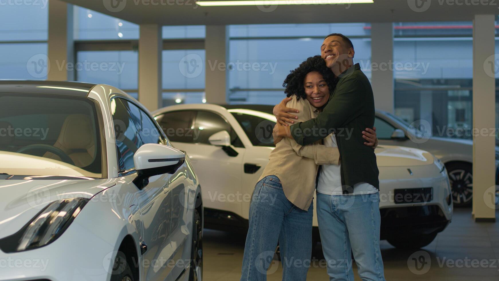 African American couple buyers customers happy owners joyful smiling woman man cuddling choosing modern car at vehicle salon showroom rent buy automobile buying luxury auto dealership rental service photo