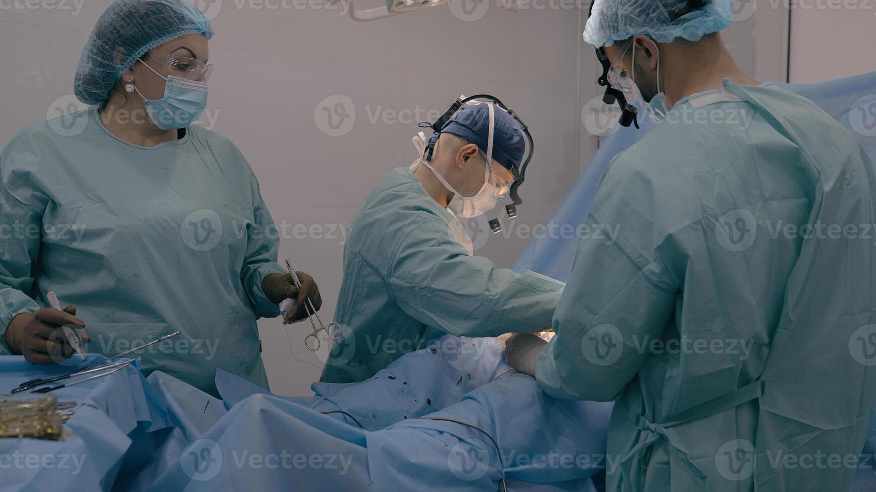 Surgeon with assisting man doctor operating patient perform surgical procedure. Nurse woman stand at table with medical instruments cut out appendicitis malignant tumor heart disease surgery process photo