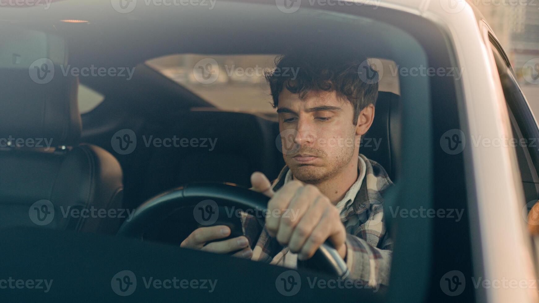 Disappointed stressed sad man Caucasian auto driver businessman inside automobile car waiting in traffic jam using mobile phone read bad news upset displeased loss gps navigation road driving in city photo