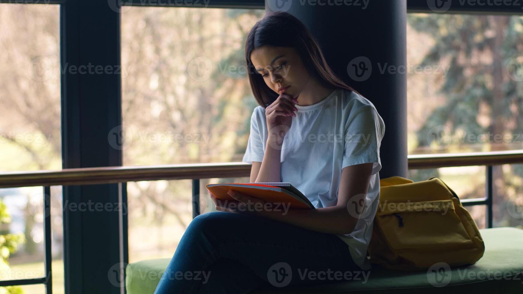 Caucasian pensive thinking thoughtful girl female woman student pupil schoolgirl lady study education outside in city near school university college looking at notebook holding copybook textbook think photo