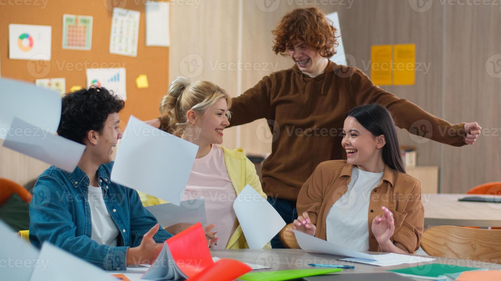 Happy smiling friends education school university finish complete holiday weekend session diploma done graduate pass exam Caucasian girls guys boys female male students together studying throw papers photo