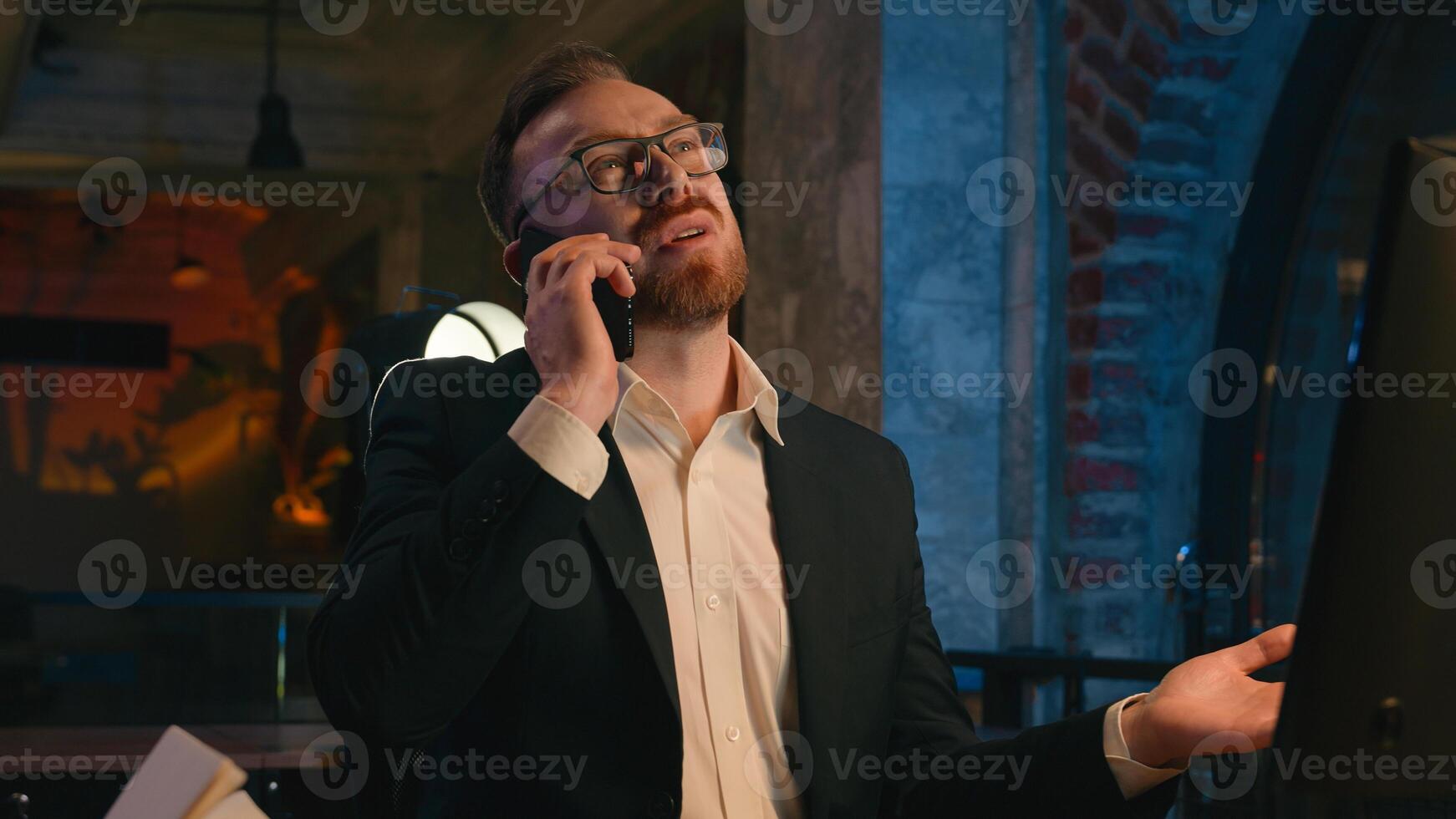 Busy workaholic deadline late time working businessman Caucasian office business man dissatisfied angry upset irritated guy male work at dark night evening overtime call talking mobile phone problem photo