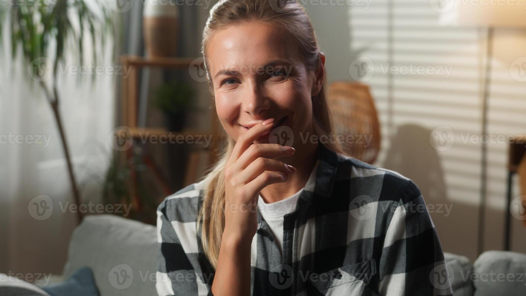 Portrait indoors at home happy funny smiling joyful positive Caucasian woman adult female girl lady homeowner looking at camera laughing smile joke fun humorous reaction amazed close mouth with hand photo