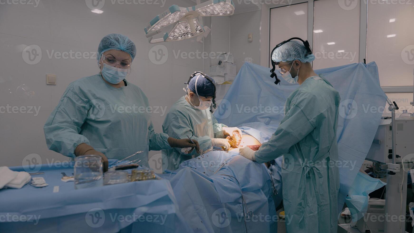 Medical team men doctors physicians surgeons nurse processing surgical operation in hospital clinic emergency medicine heart stomach surgery cut out appendicitis cancer tumor disease health patient photo