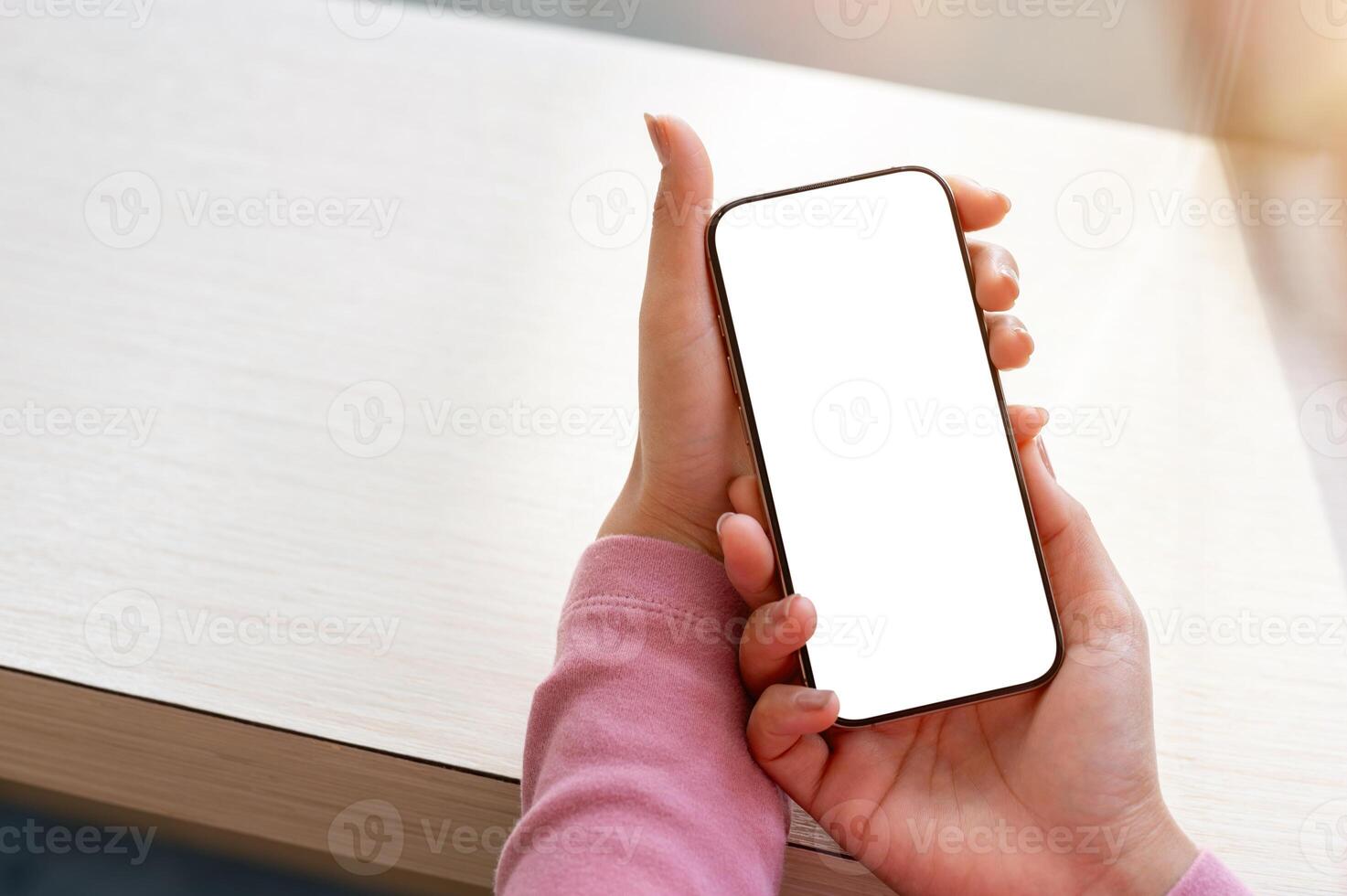 A close-up of a woman relaxing in a coffee shop while using her smartphone. photo