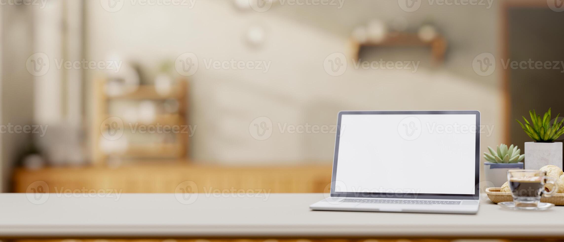A close-up of a laptop and decorative items on a desk in a minimalist coffee shop. photo