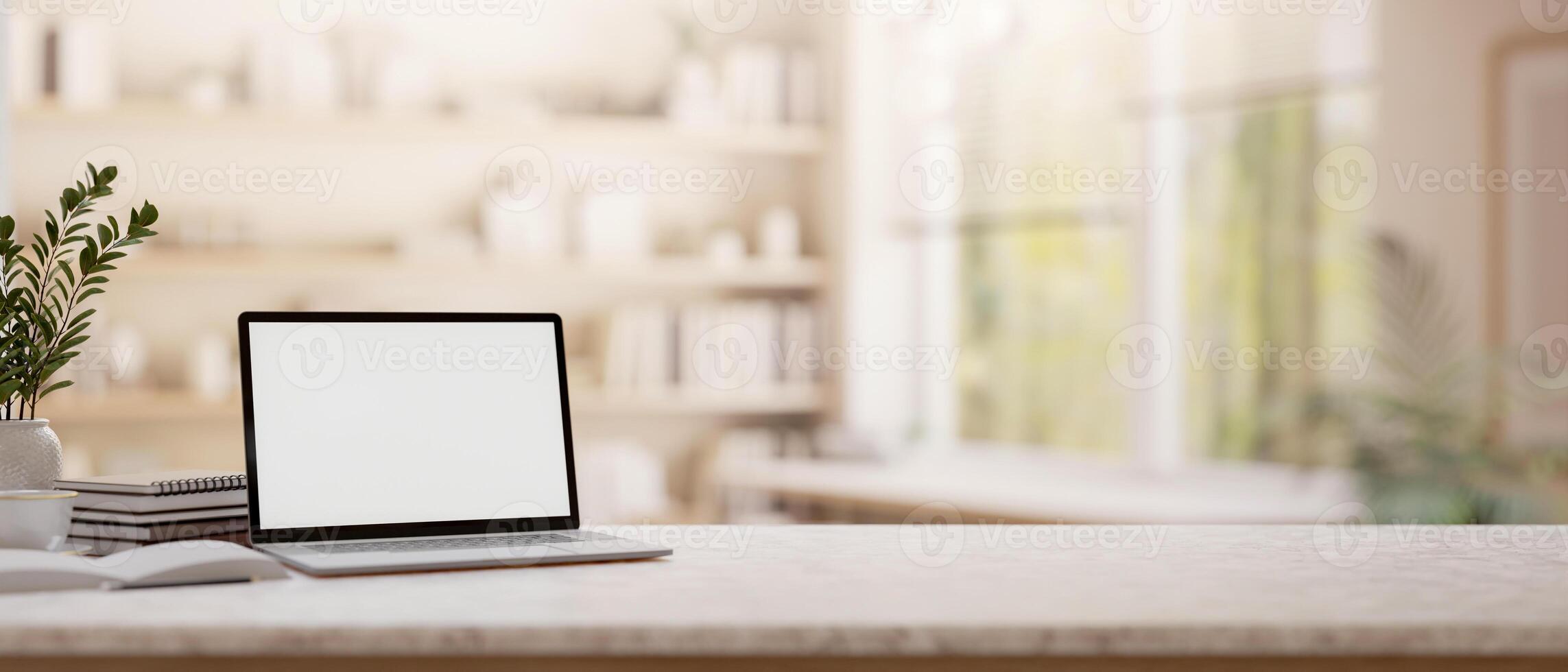 A laptop on a tabletop with blurred background of a minimalist room. photo