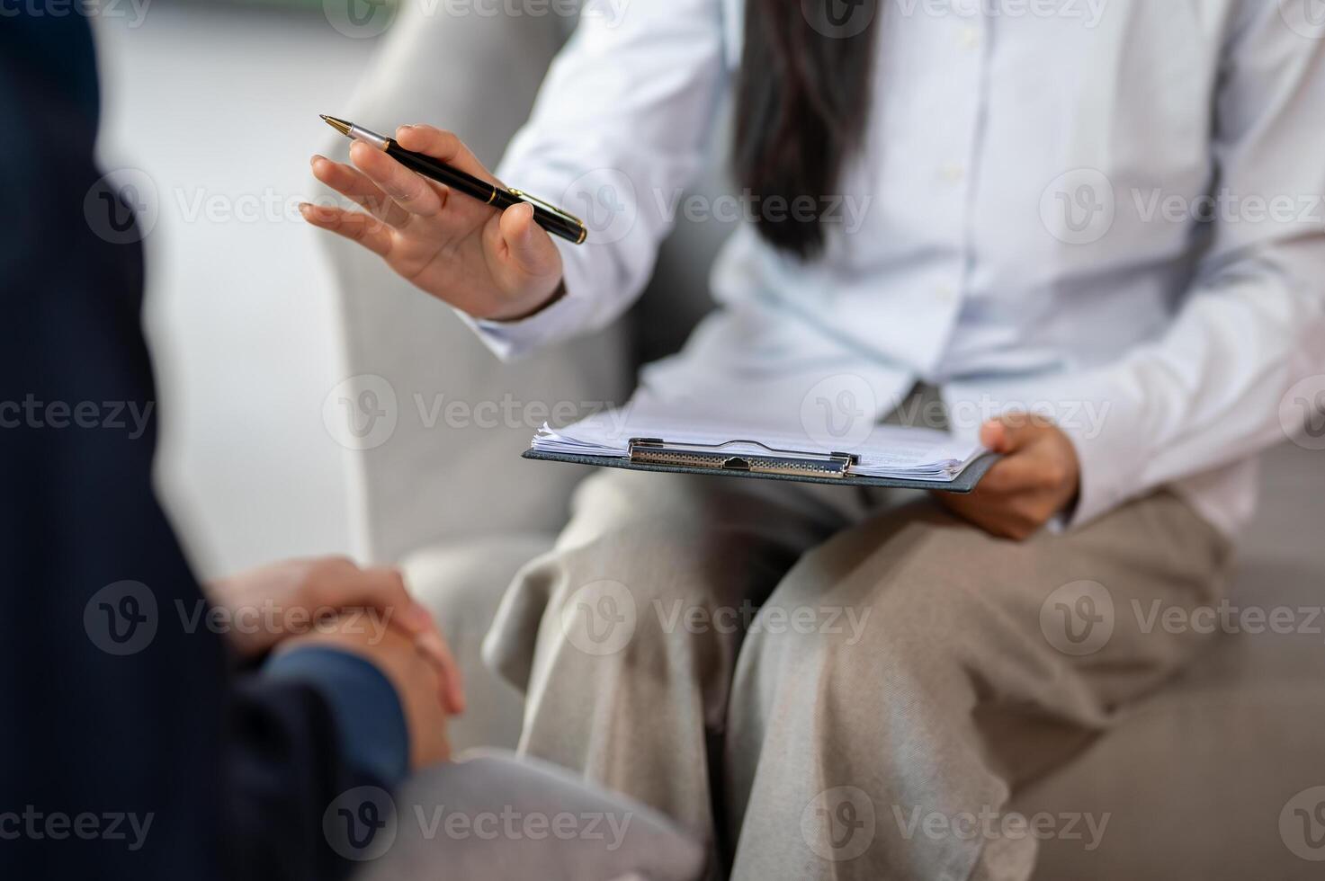 A close-up of a psychologist sitting on a sofa, carefully talking to a patient, offering advice. photo