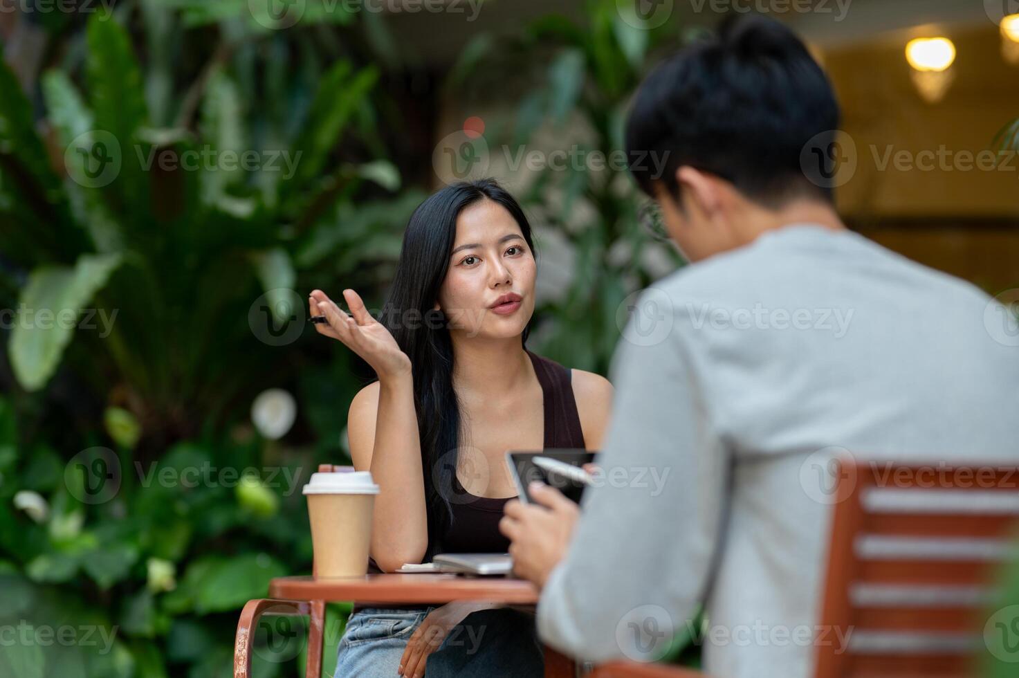 A gorgeous, confident Asian woman having an informal meeting with her colleague or client at a cafe. photo