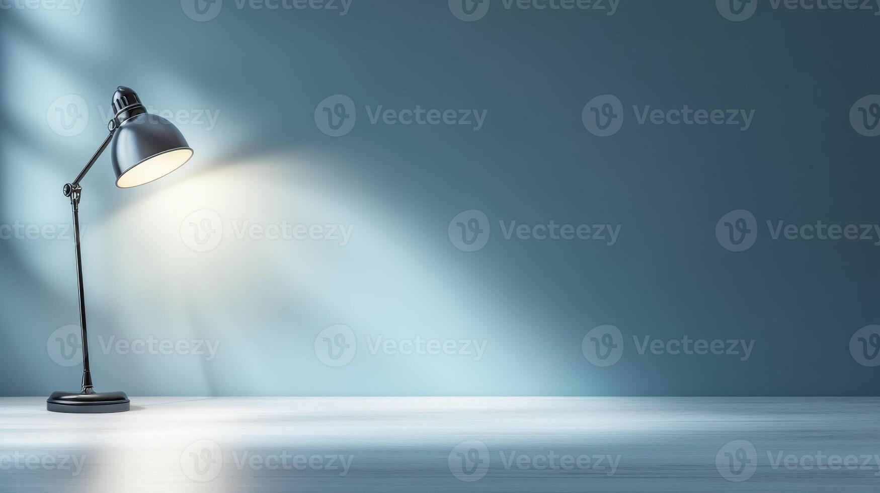desk lamp casting soft glow on simple workspace with blue wall photo