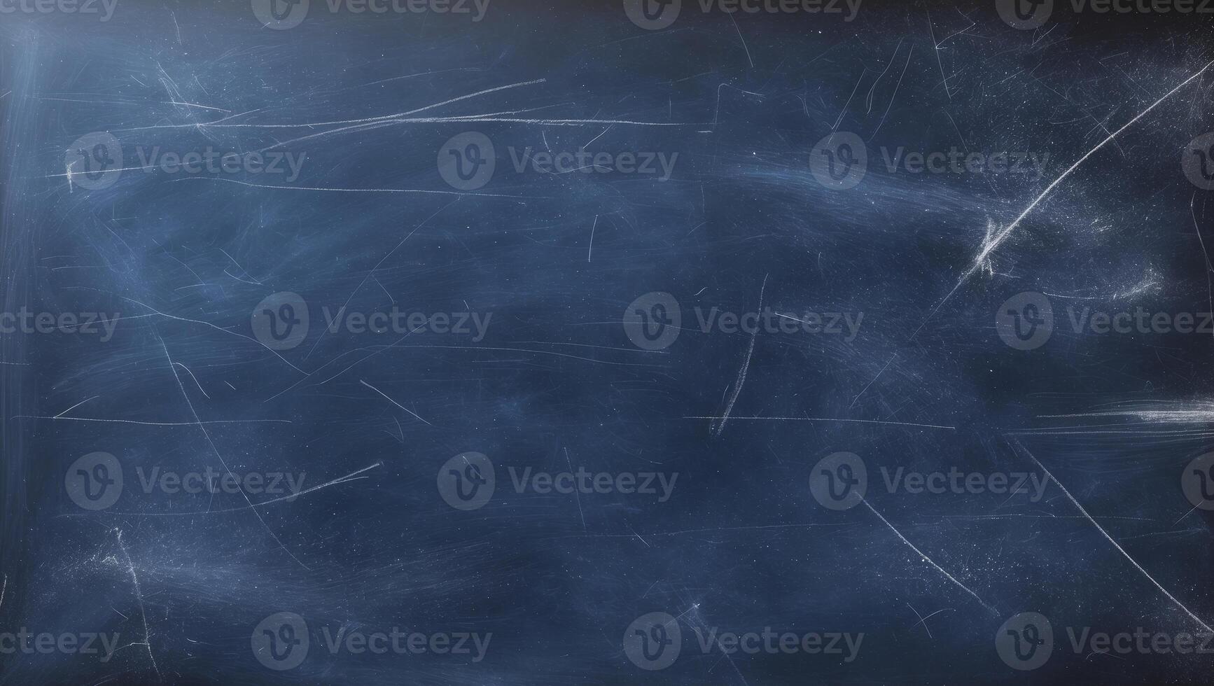 A copy space image of a dark blue chalkboard with traces of erasing creating a textured background photo