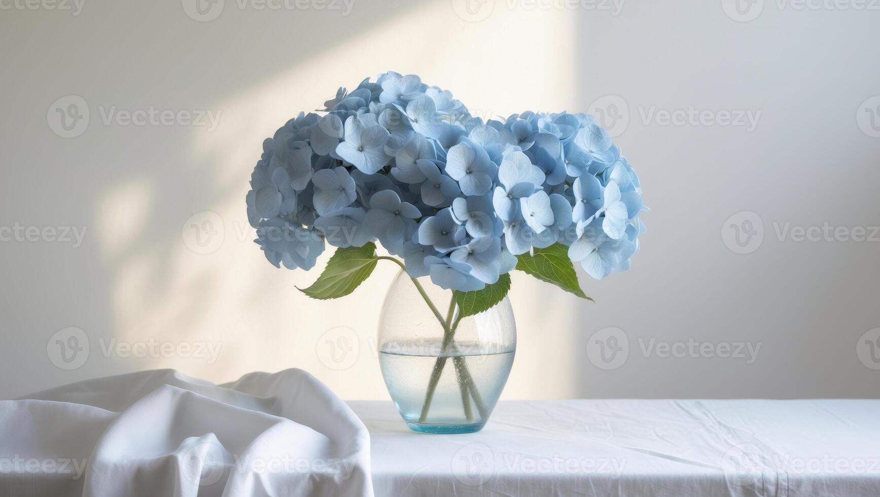 Blue Hydrangeas in Clear Vase on White Table photo