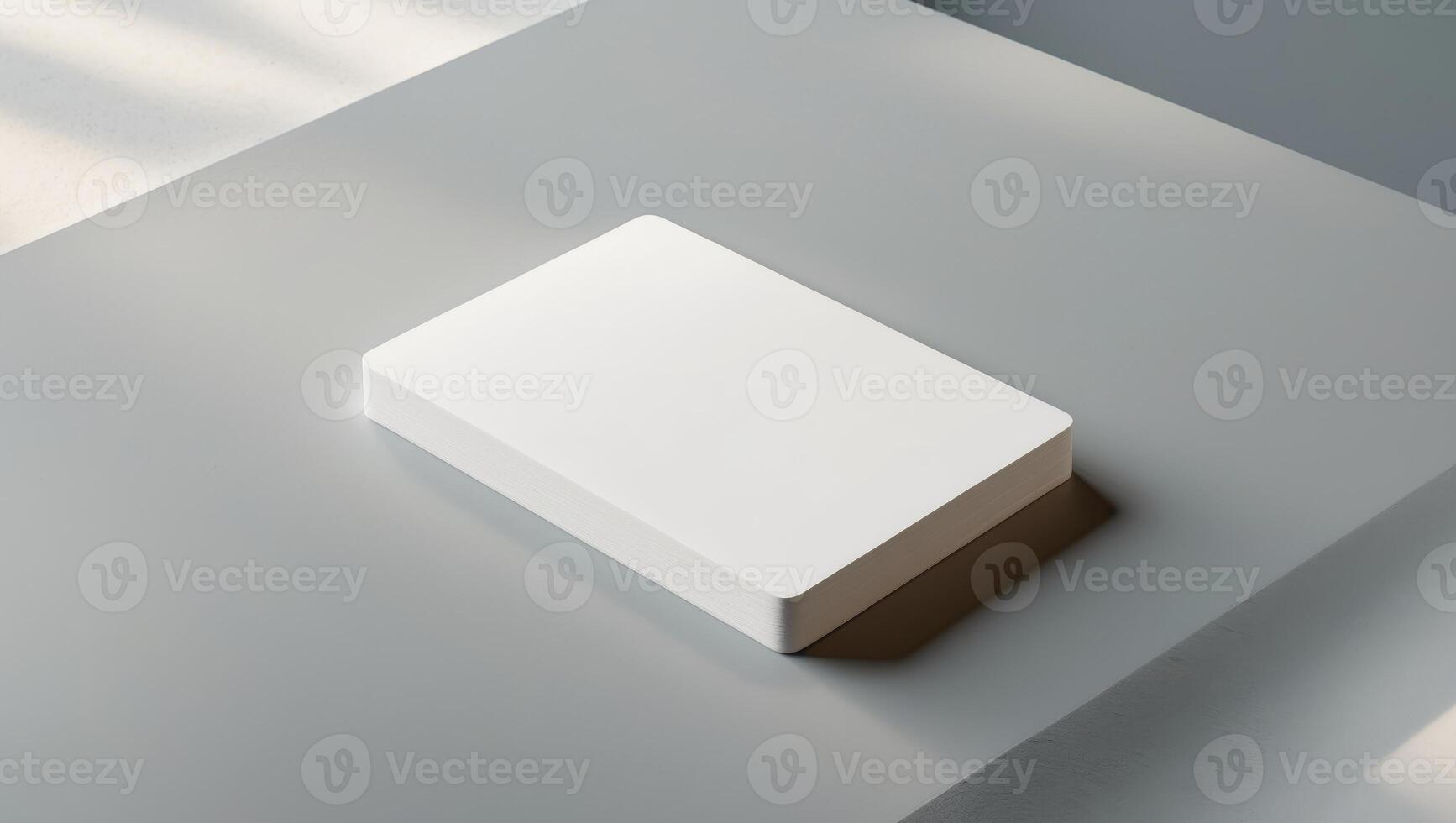 A white card is sitting on a grey surface. photo
