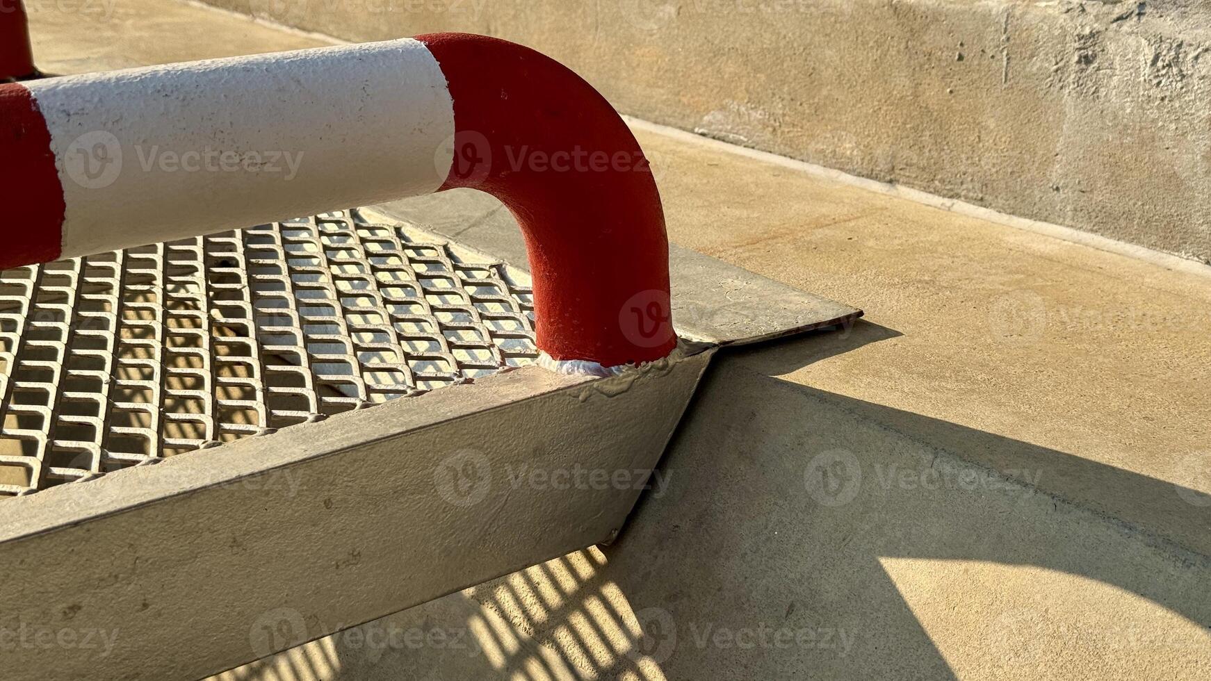Industrial Walkway Detail Close-up view of a metallic industrial walkway with red and white safety handrail, showcasing the precise construction and safety features. photo