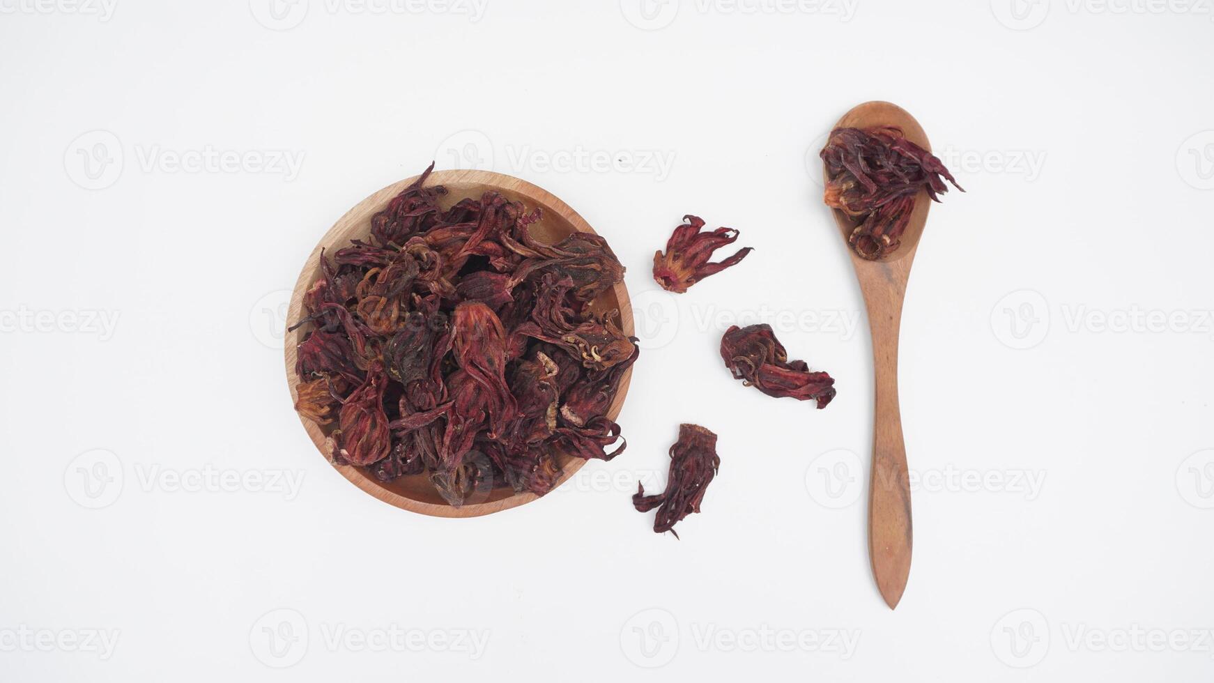 Top View of A Bunch of Dried Red Roselle on Wooden Plate and Spoon with Selective Focus on White Background photo