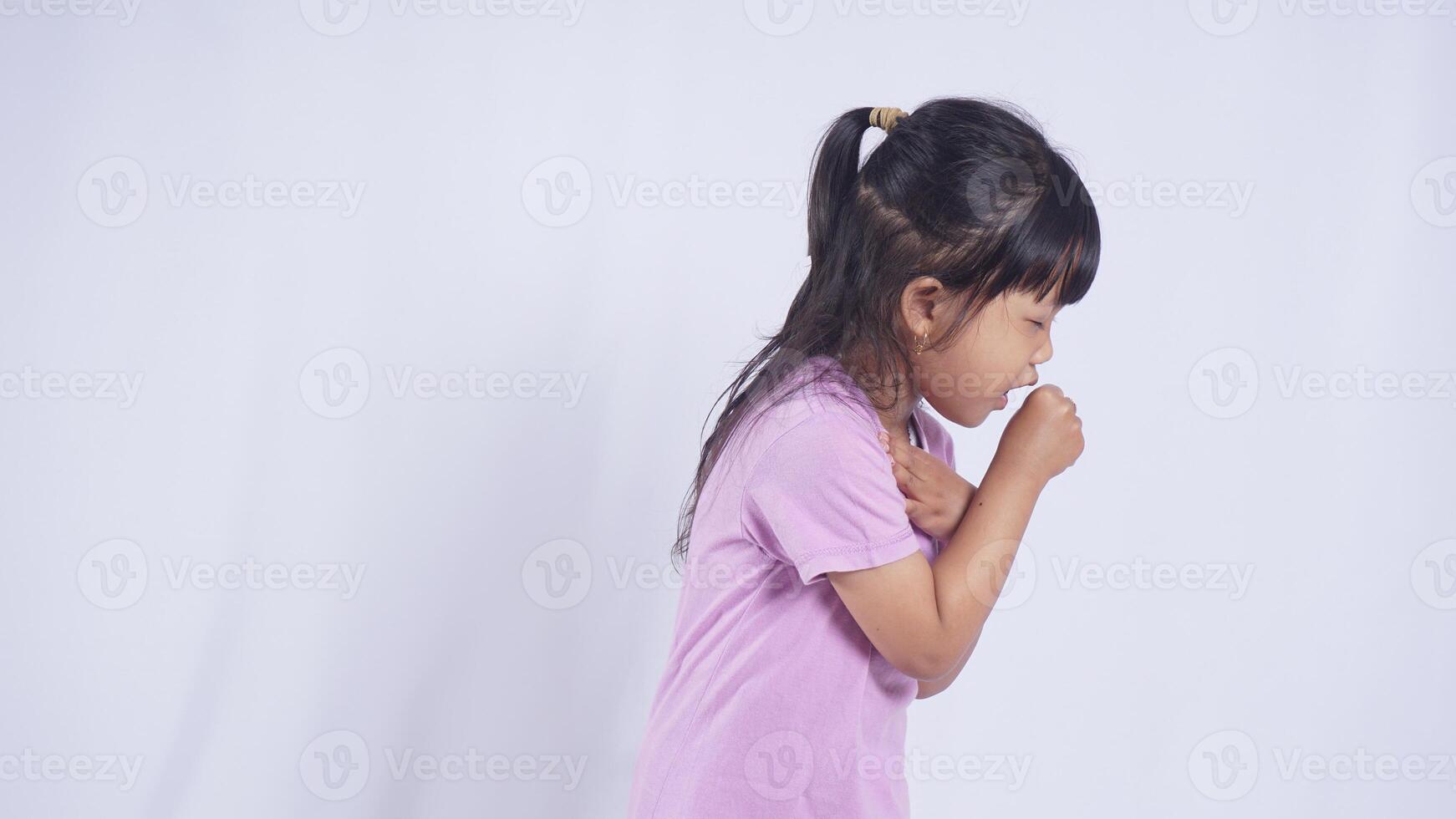 Side View of Asian Little Girl Suffering from Severe Cough on White Background photo