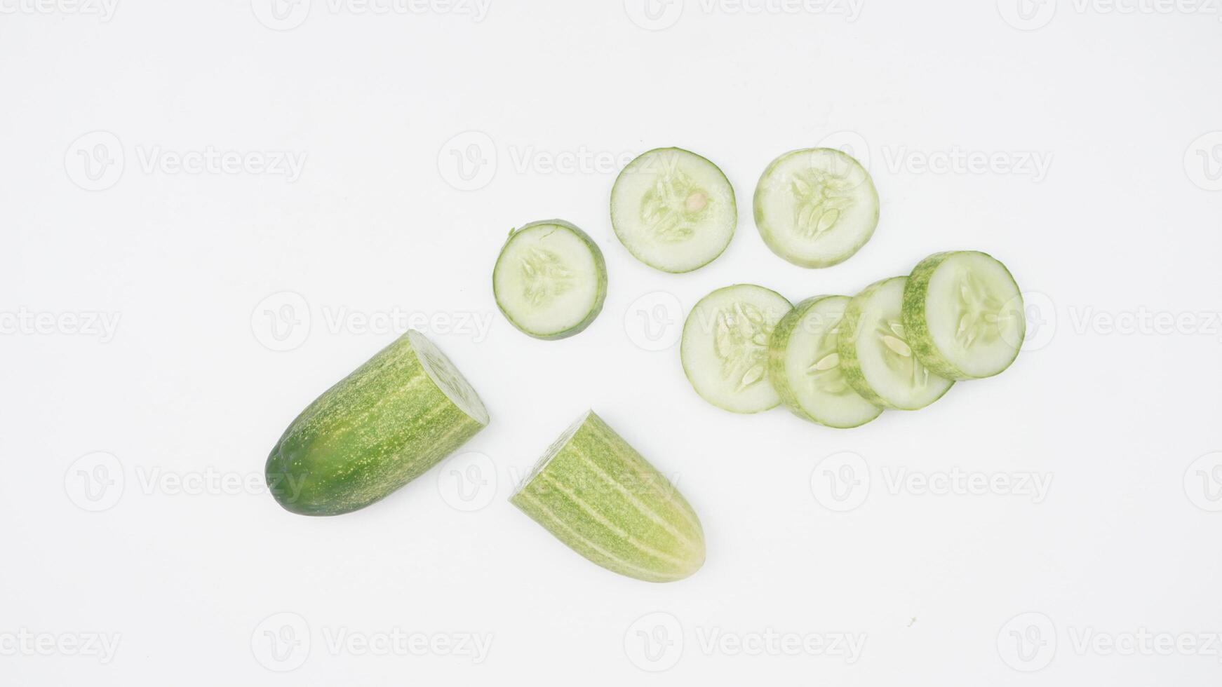 Half and Slices of Cucumber on White Background photo