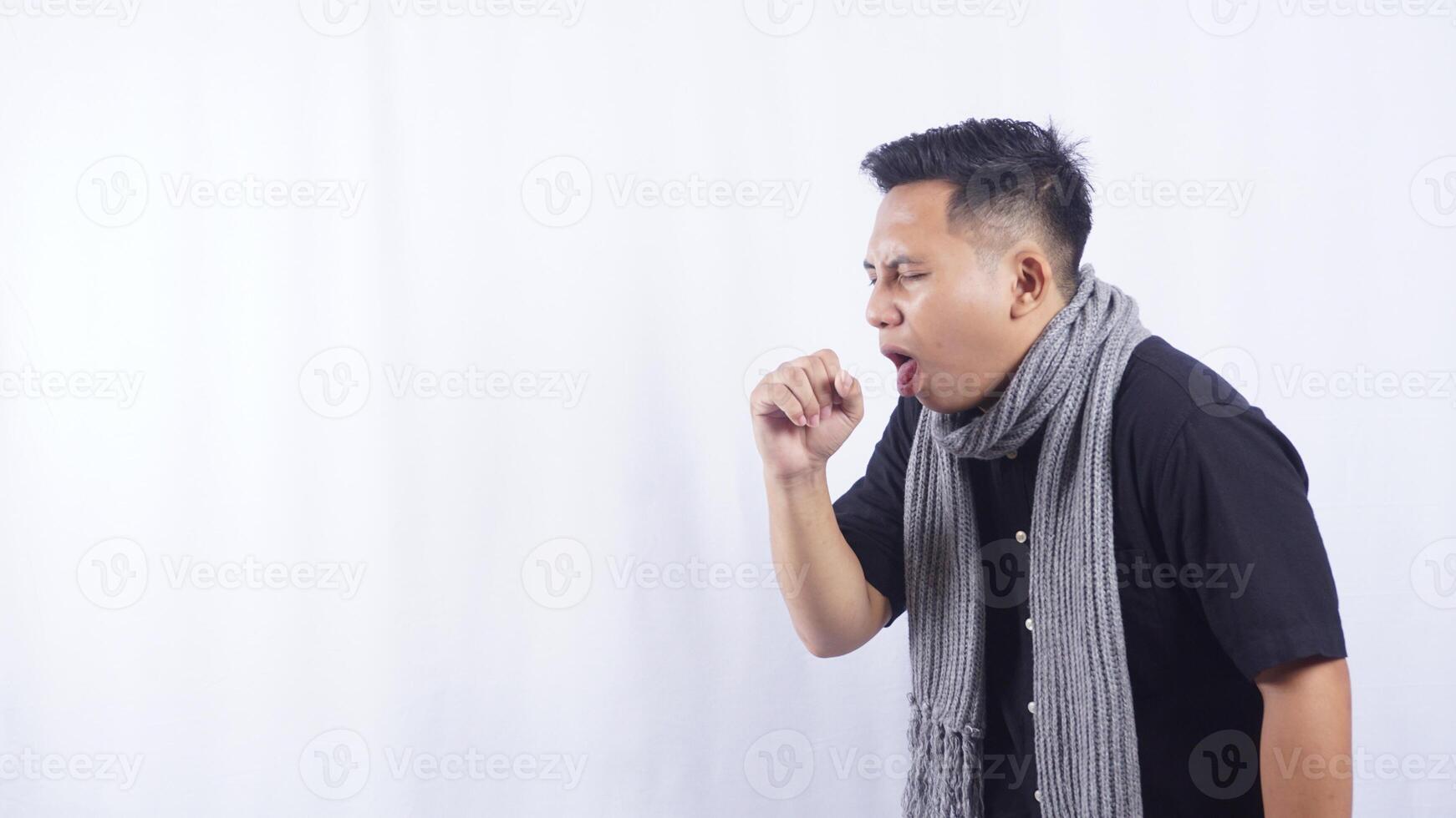 Side View of Young Asian Man with Coughs Into His Hand on White Background photo