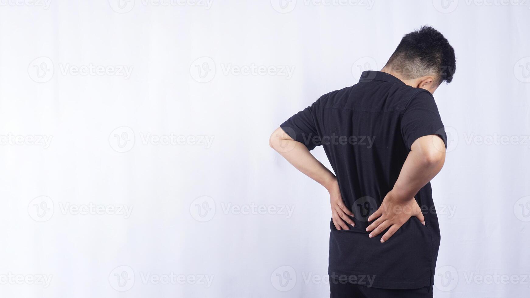 Rear View of Young Man Suffering from Back Pain on White Background photo