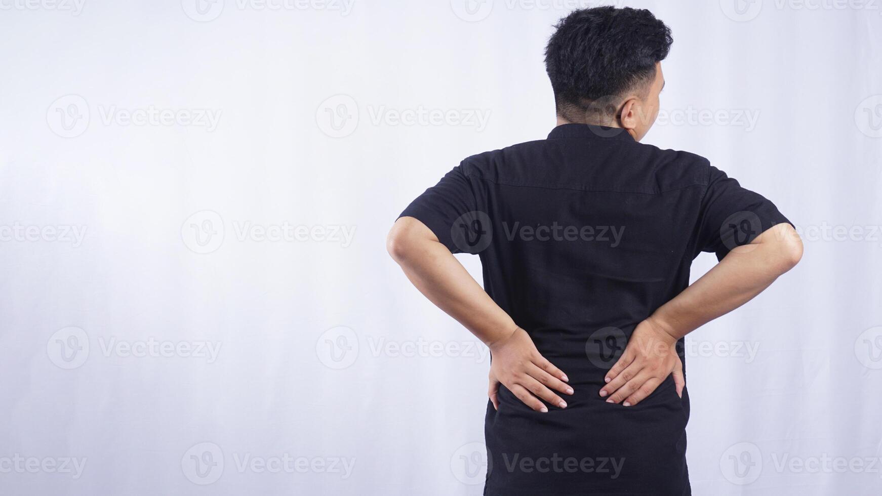 Rear View of Young Man Suffering from Lower Back Pain on White Background photo