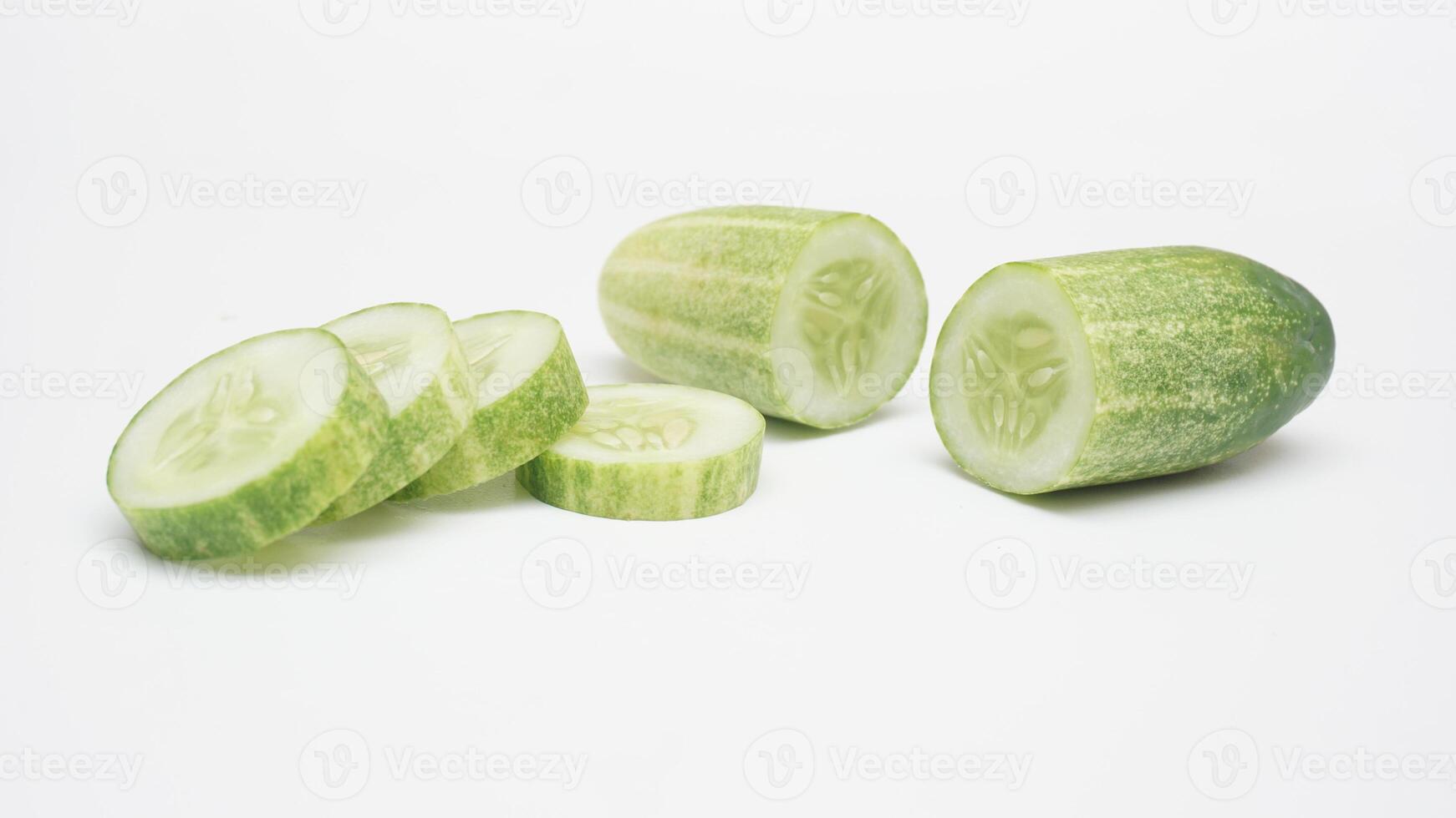 Fresh Half and Slices of Cucumber on White Background photo