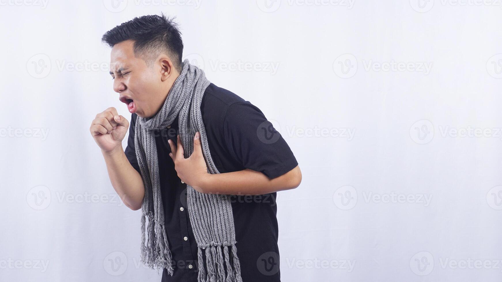 Side View of Young Asian Man Feeling Chills and Suffering from Cough on White Background photo