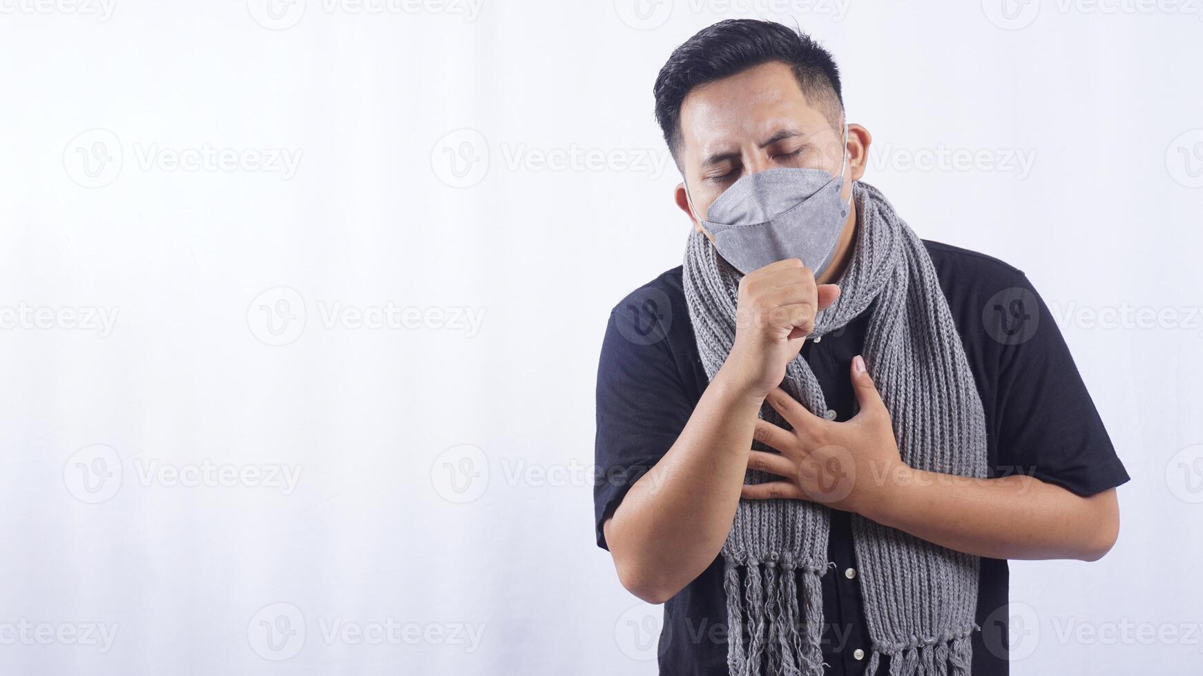 Young Man Wearing Mask Coughing on White Background photo