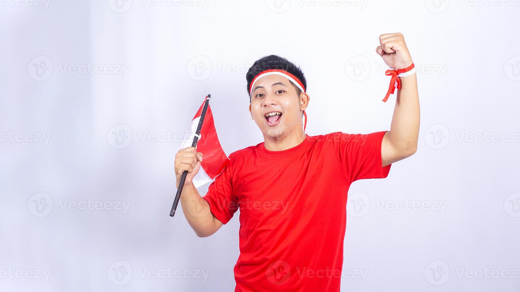 Portrait of Indonesian Man Celebrate Independence Day of Indonesia Holding Red and White Flag photo