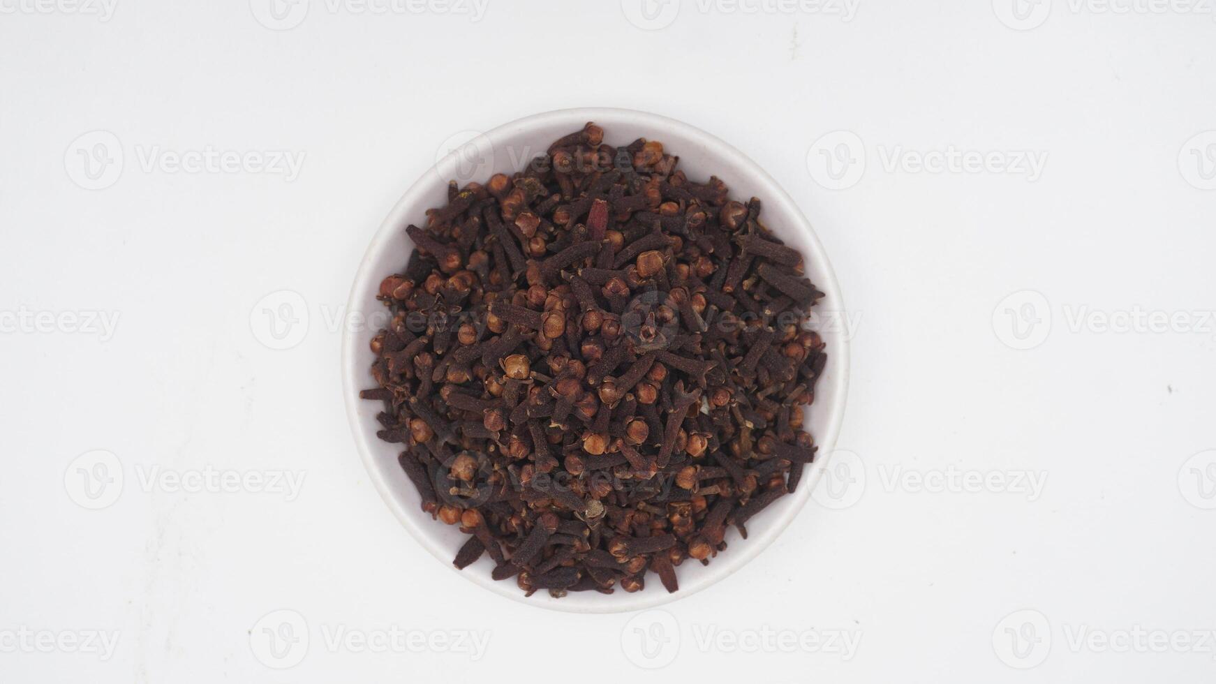 Top View of Dried Cloves Spice on Plate on White Background photo