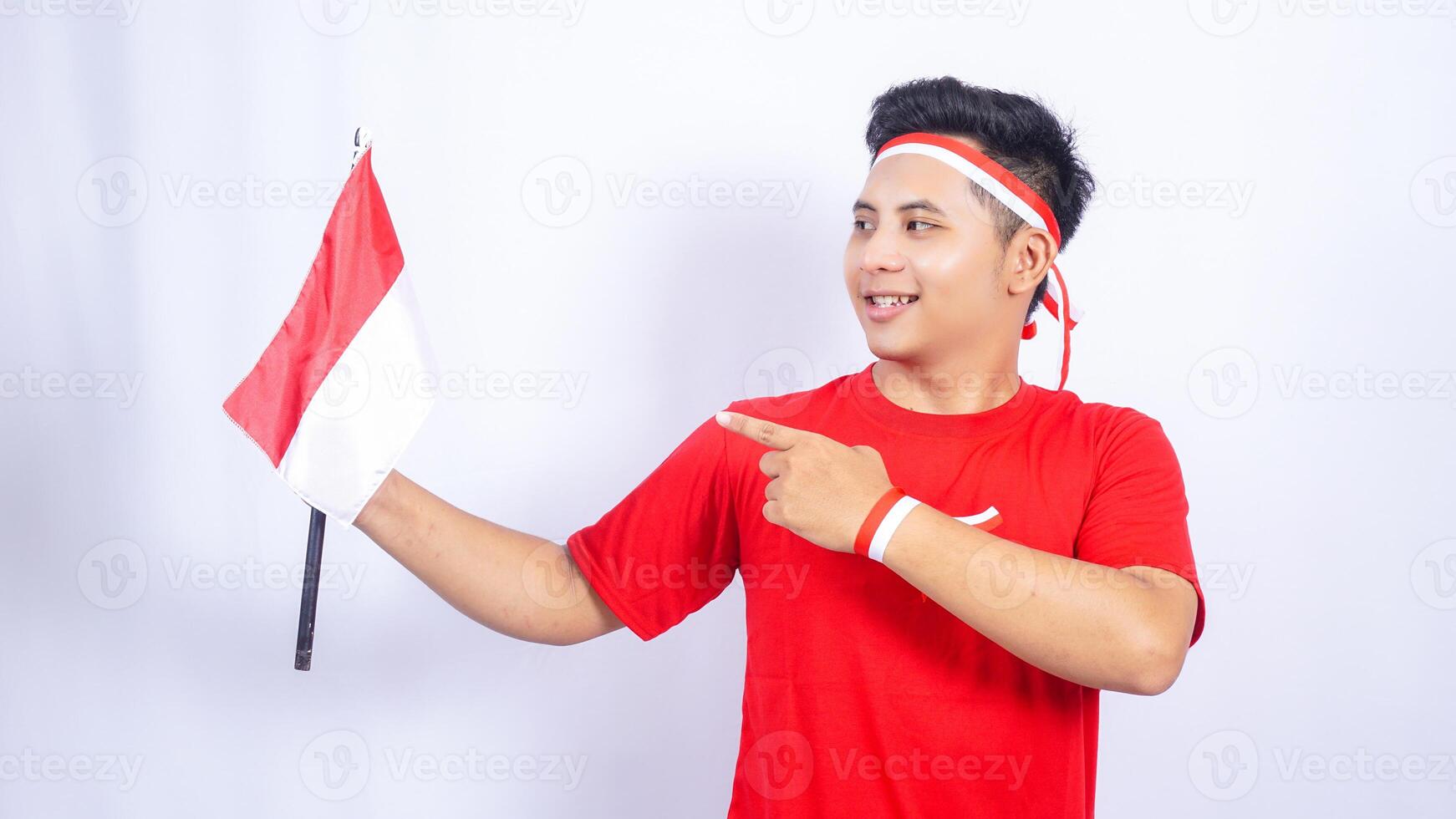 Portrait of Indonesian Man Pointing to Red and White Indonesia Flag on White Background photo