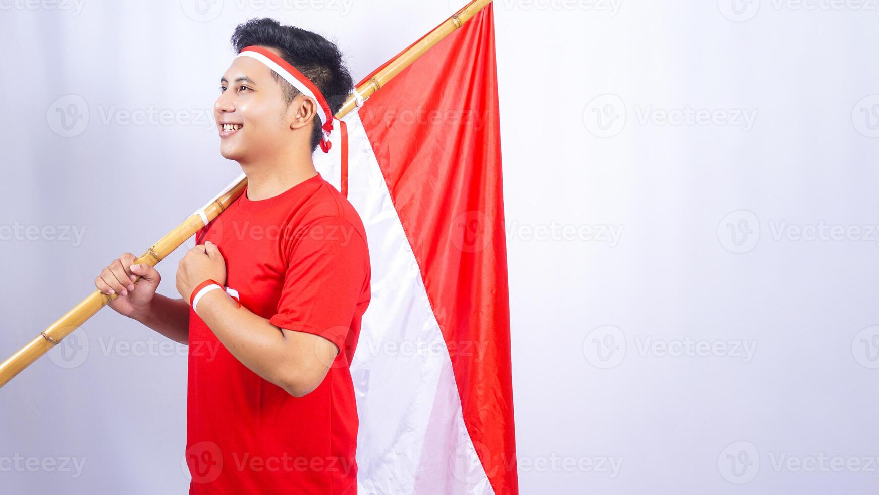 Indonesian Man with Red and White Flag Showing Salute Pose on White Background photo