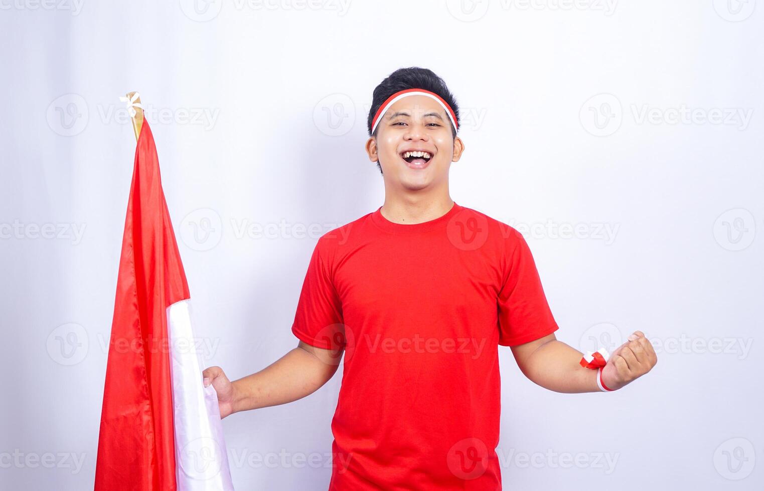 Portrait of Indonesian Man with Red and White Attribute Showing Happy Expression on White Background photo