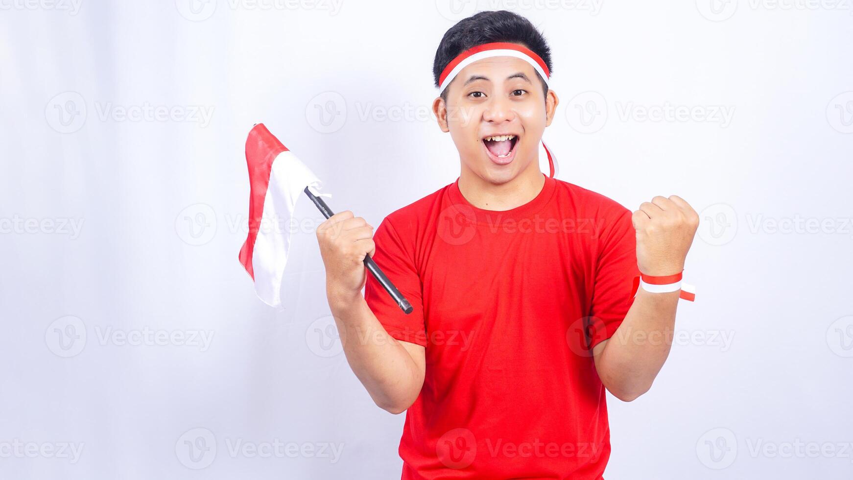 Excited Indonesian Man with Red and White Ribbons Showing Yes Gesture Celebrate Independence Day of Indonesia on White Background photo