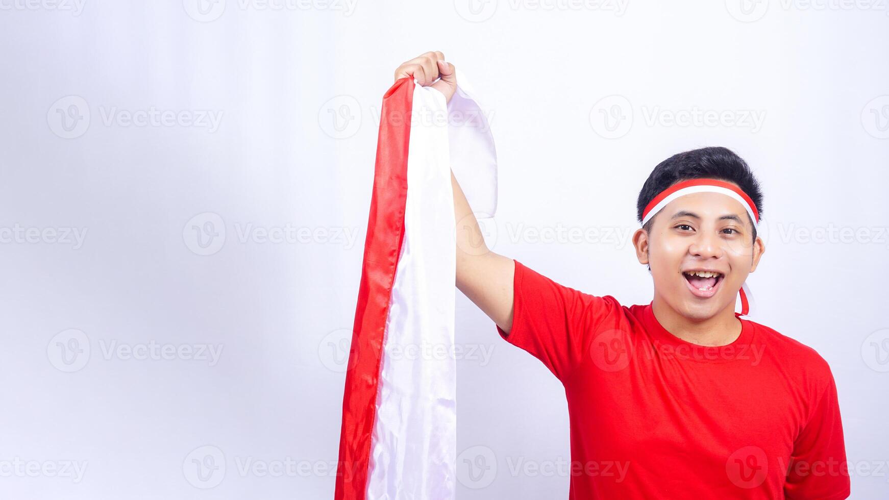 Portrait of Indonesian Man Holding Red and White Indonesia Flag on White Background photo