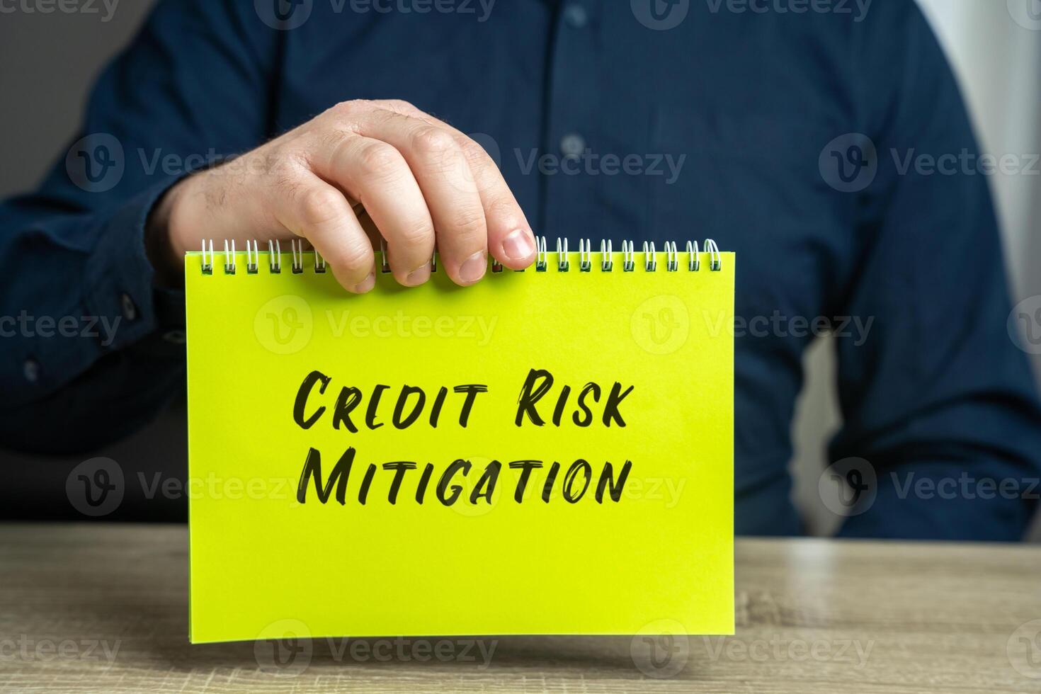 Credit Risk Mitigation concept. Minimizing the risk of losing money due to failure to fulfill interest payment obligations. Conceptual image with a businessman and a notepad in his hands. photo
