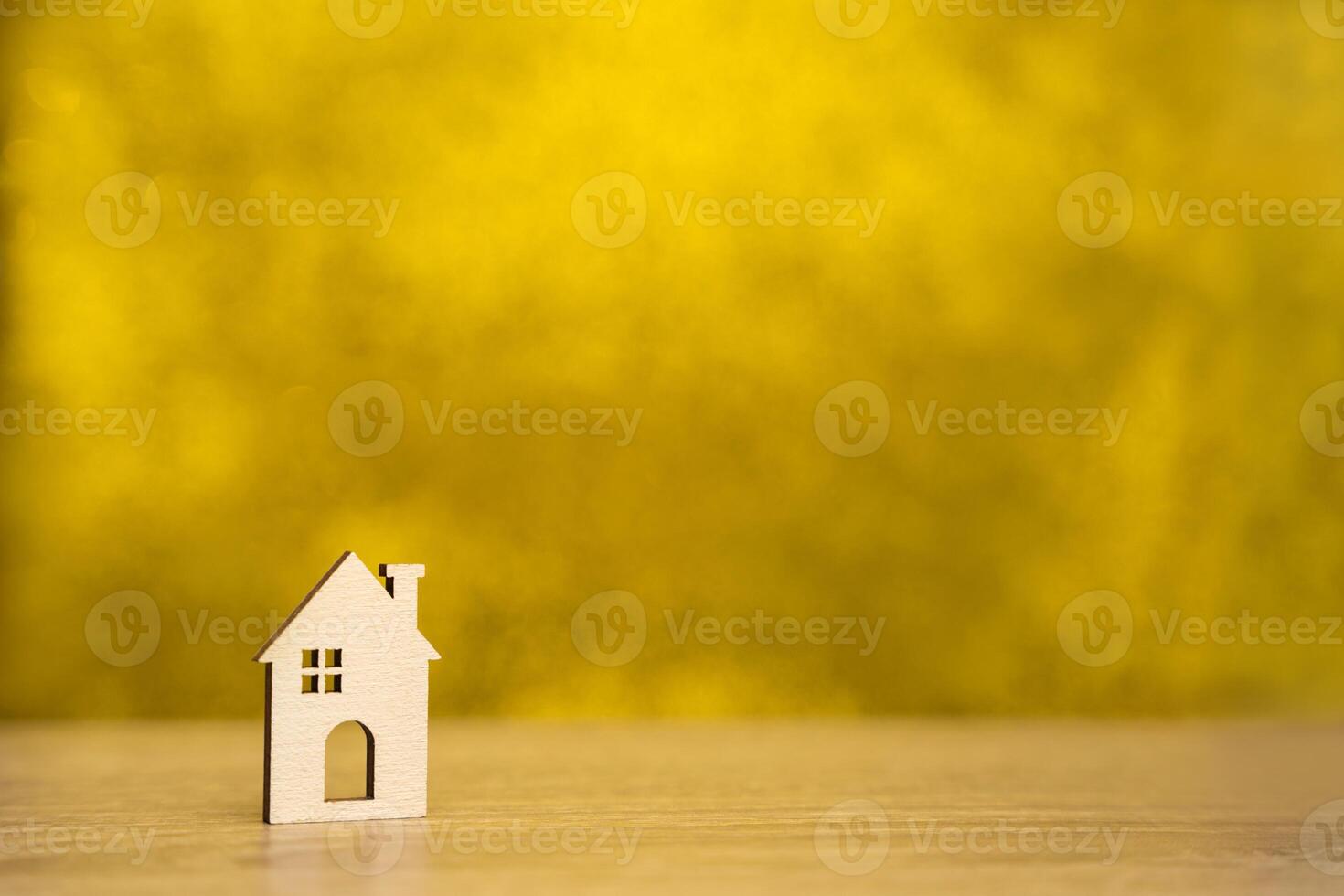Miniature wooden house on a yellow background. Real estate and affordable housing concept. Mortgage, loan and insurance of apartments. Selling and buying home. Copy space photo