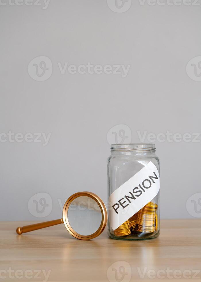 Bank of coins and the inscription Pension. Saving money and retirement concept. Accumulation of pension contributions. Business and finance. Magnifying glass photo