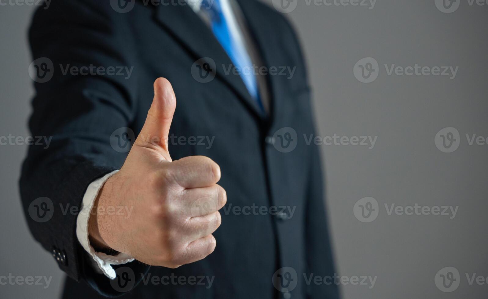 A businessman shows a thumbs up as a sign of approval and acceptance. Agreement satisfaction. Negotiation success. Professional recognition. Recruitment for work. photo