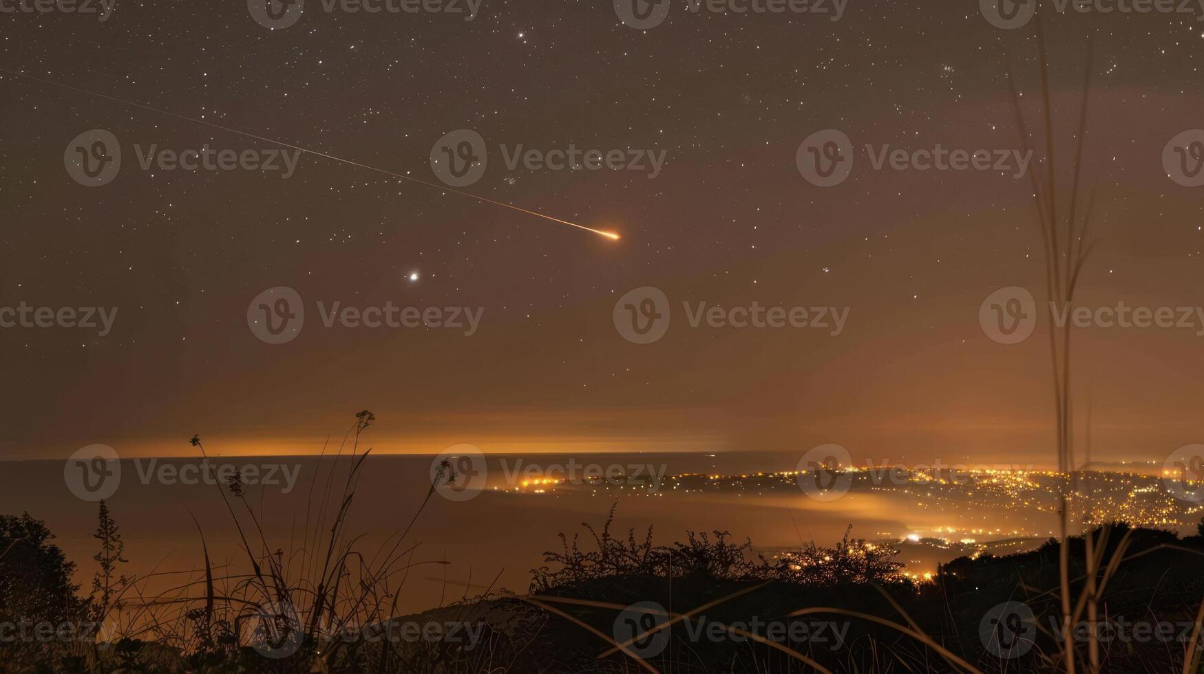 Night sky over coastal city with shooting star, illuminated skyline, and serene landscape photo