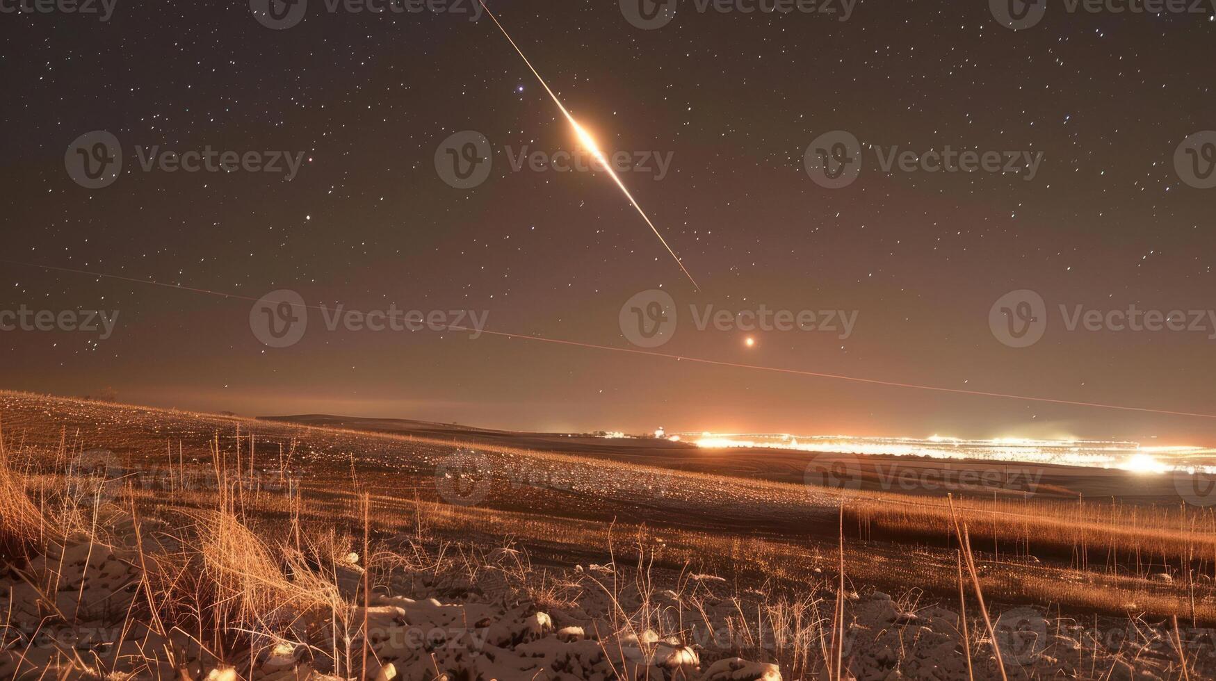A stunning night sky with a meteor streaking over a snowy landscape illuminated by city lights photo