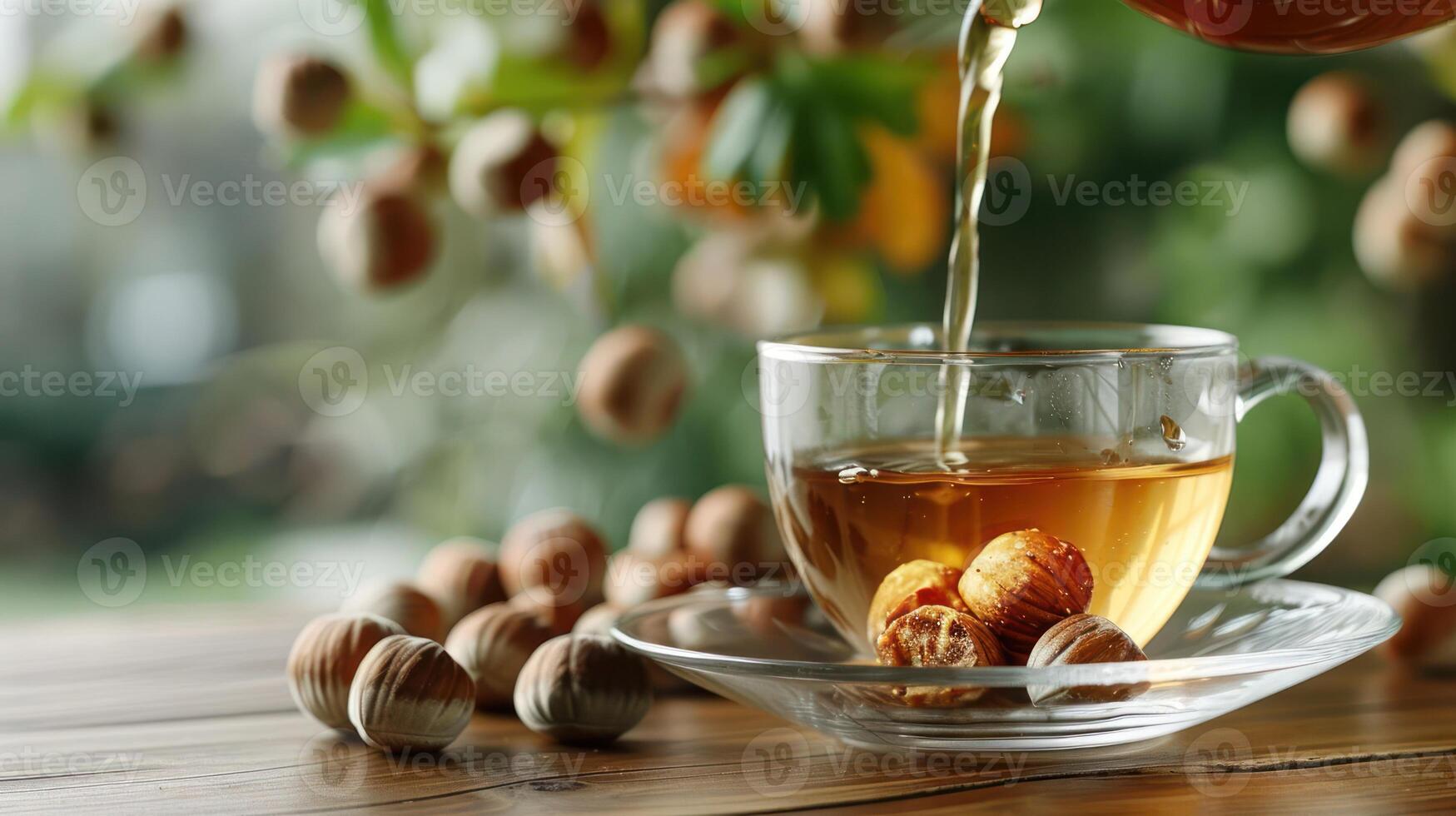 A steaming cup of tea being poured, surrounded by hazelnuts and a lush, blurred garden backdrop photo