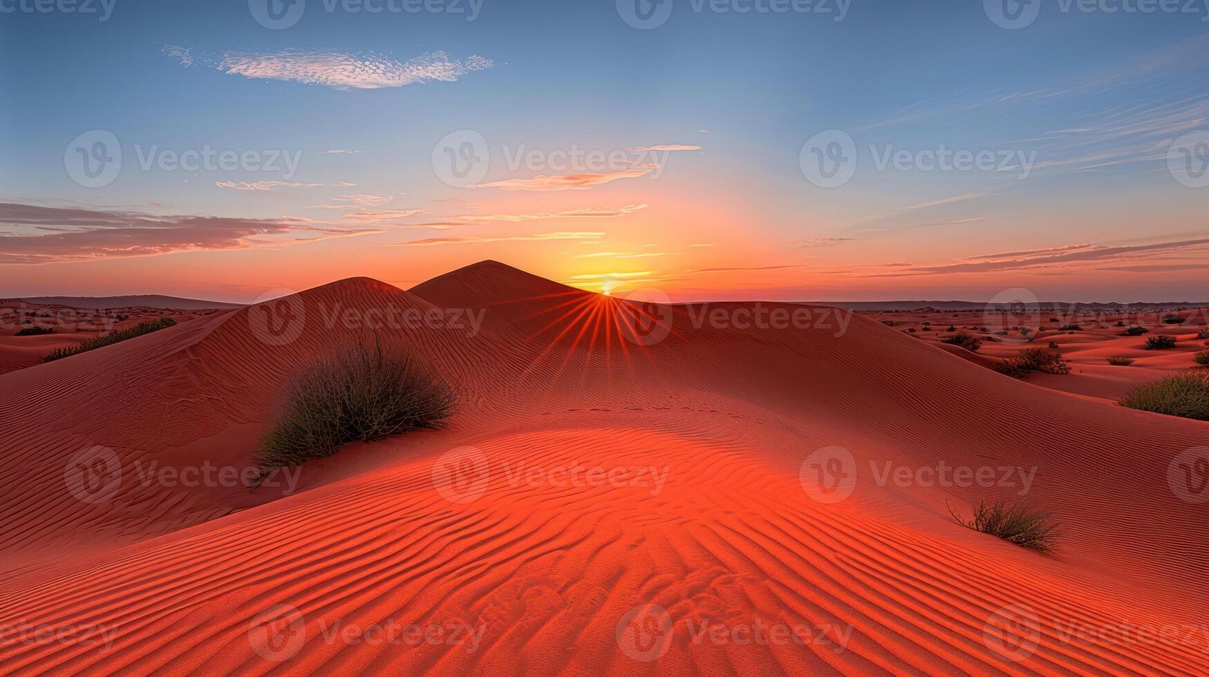 Stunning sunset over red desert dunes with vibrant sky and scattered vegetation in the background photo