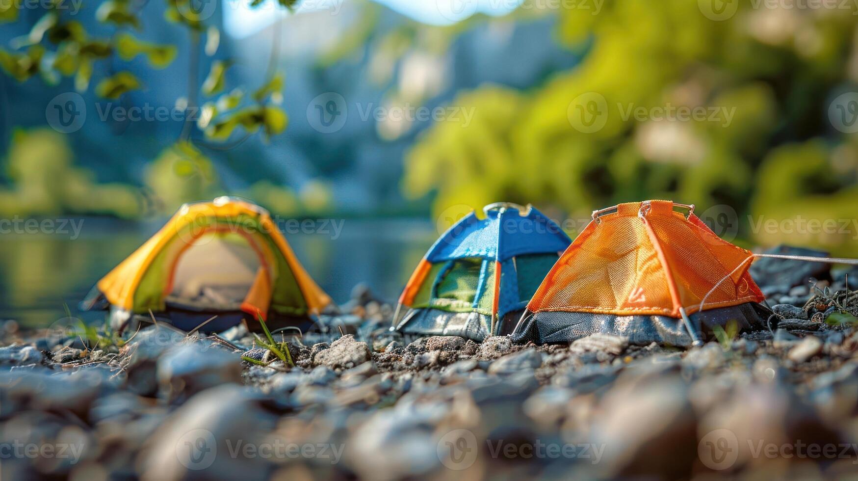 Colorful tents set up by a serene riverbank, surrounded by lush greenery and mountains photo