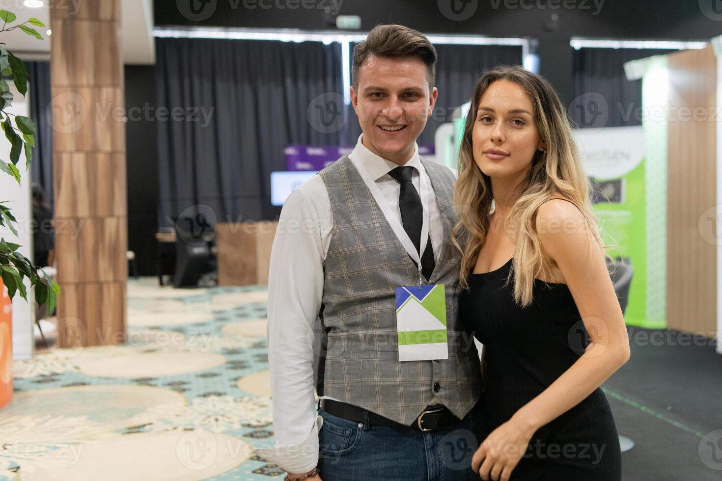 A business couple walking through a trade show, engaging with new ideas and insights to drive their professional growth photo