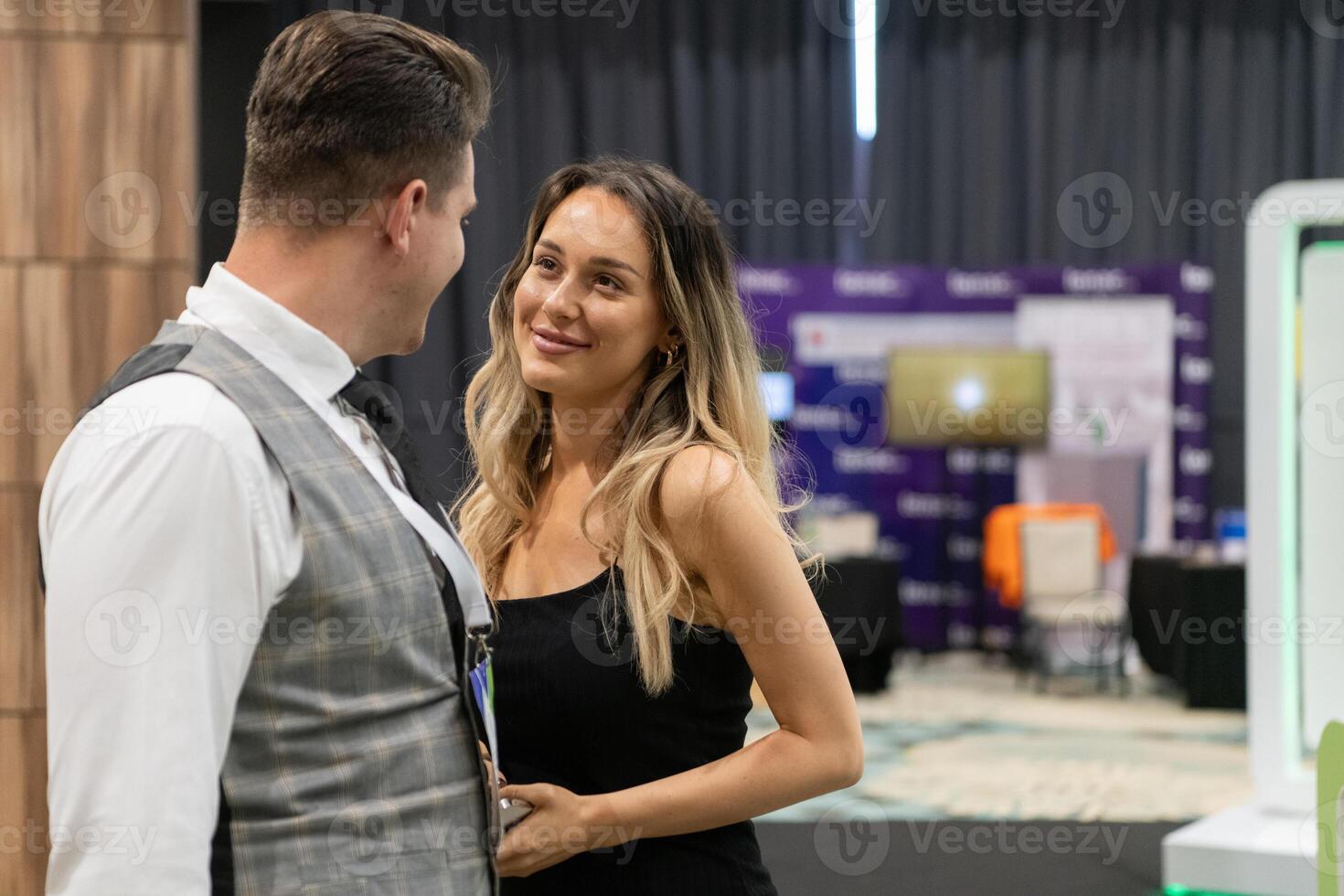 A business couple walking through a trade show, engaging with new ideas and insights to drive their professional growth photo