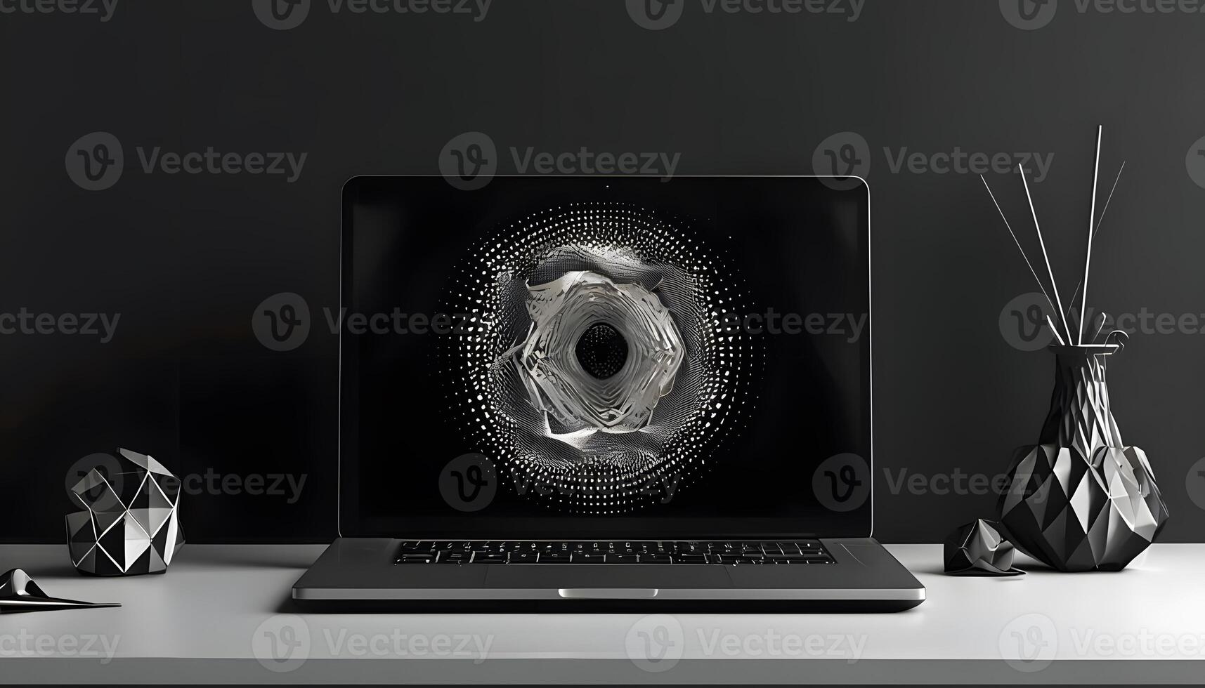 A laptop on a desk with a black and white design photo