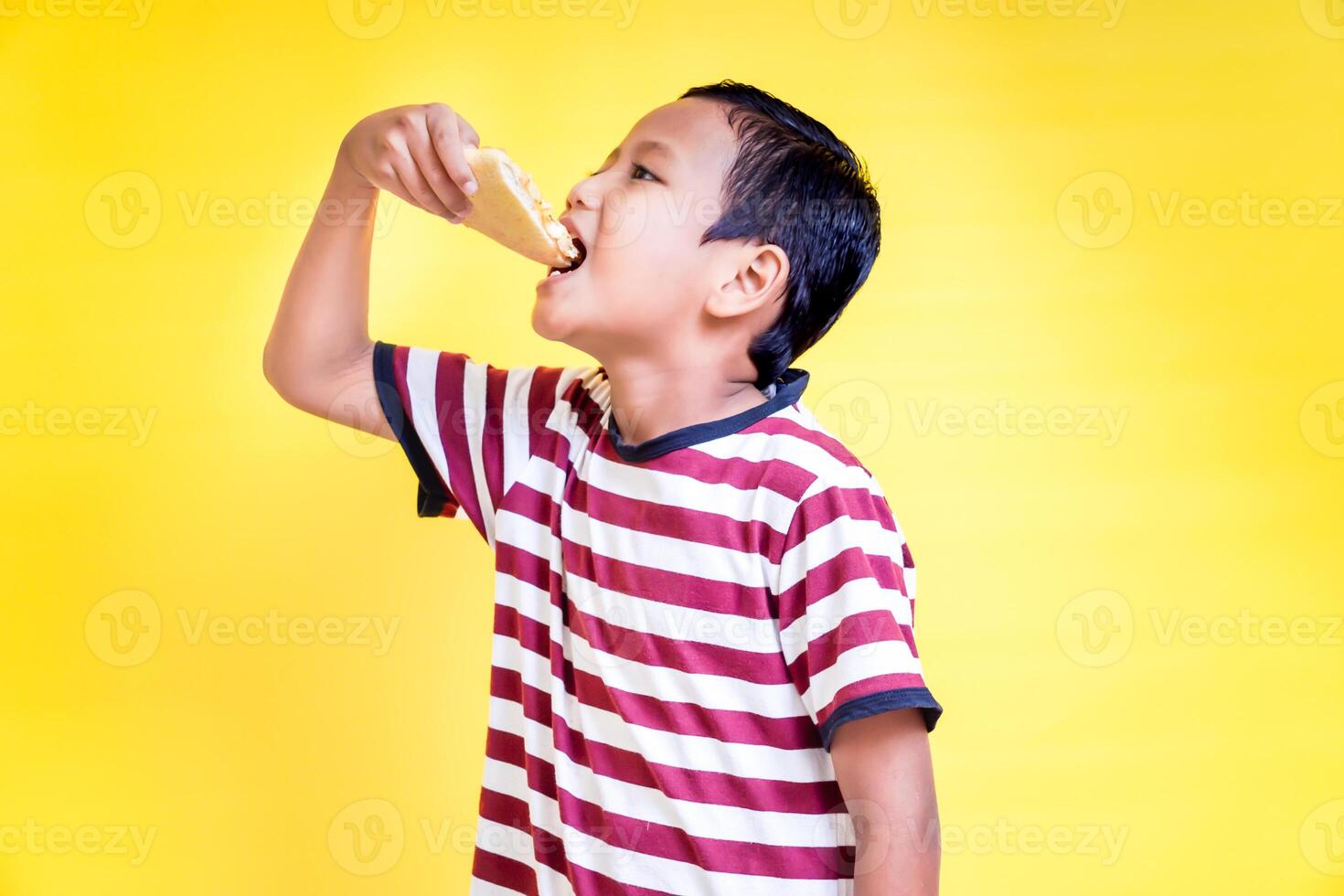 a young boy is eating a piece of pizza photo