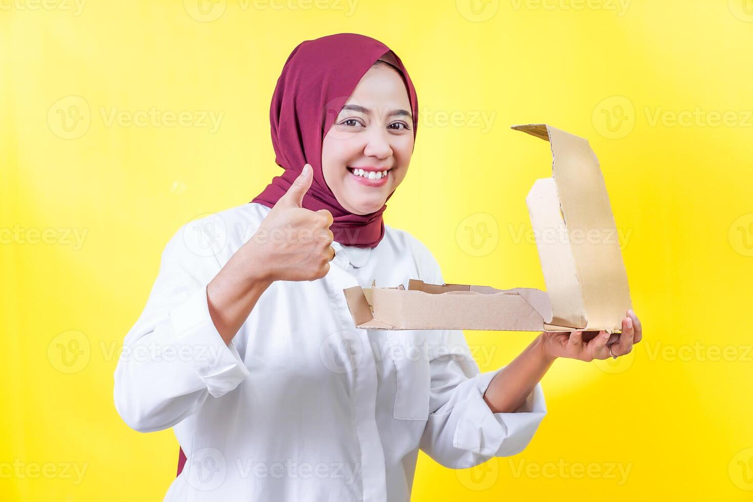 a woman in a hijab give thumbs up while holding a pizza box photo