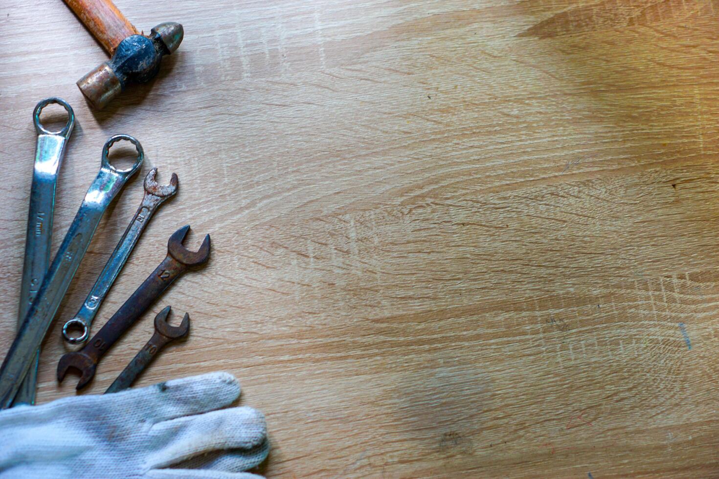 a wooden table with a pair of gloves and a wrench photo