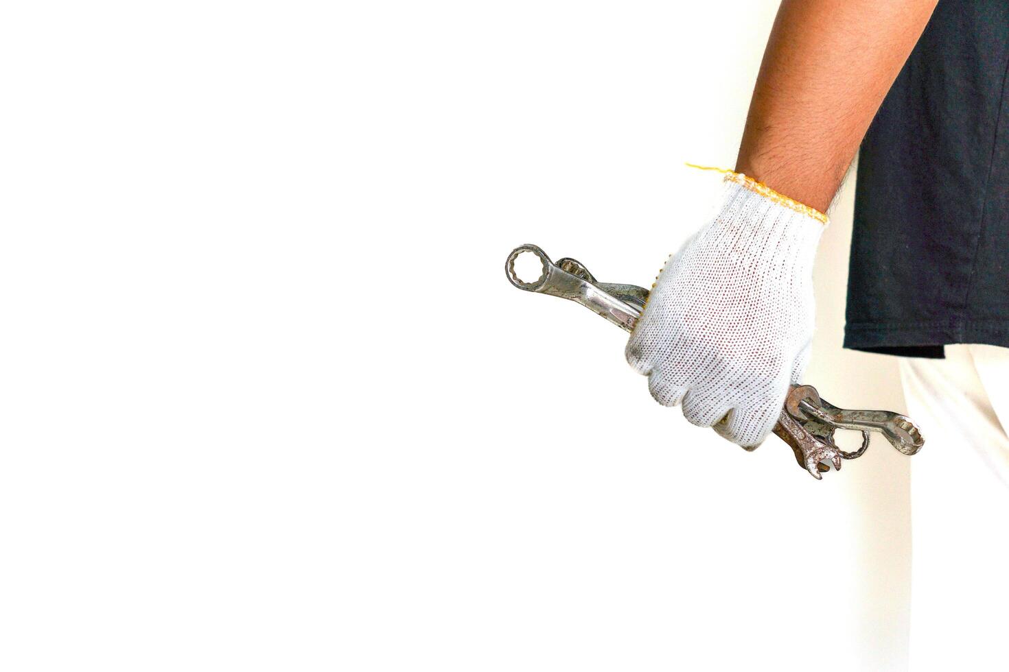 a person holding a wrench in one hand and a pair of gloves in the other photo